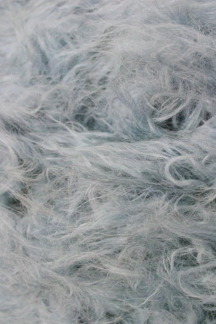 Close-up of thick wool pile on soft gray shag rug, ideal for custom wool rugs, luxury shag rugs, and plush bedroom decor