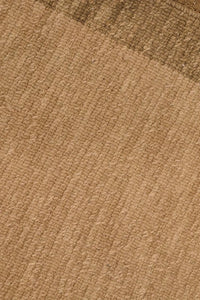 Handmade wool rug featuring soft tan tones and subtle geometric border, perfect for modern luxury living spaces and neutral interiors