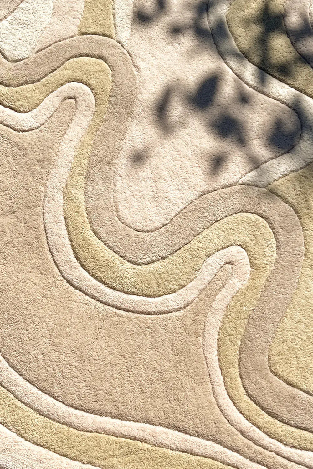 Close-up of high-low sculpted modern wool rug in cream and beige with abstract wavy design