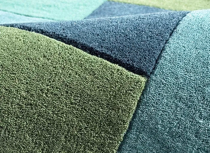 Close-up of textured green and blue tufted wool rug