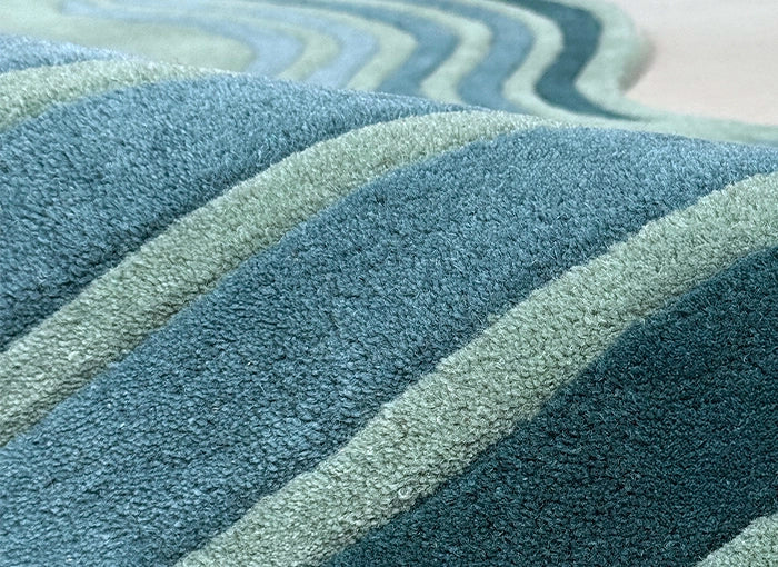 Textured rug with wavy pattern in blue and green tones