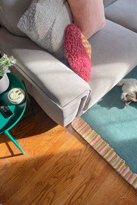 Soft modern wool rug in teal with colorful stripes in a bohemian interior