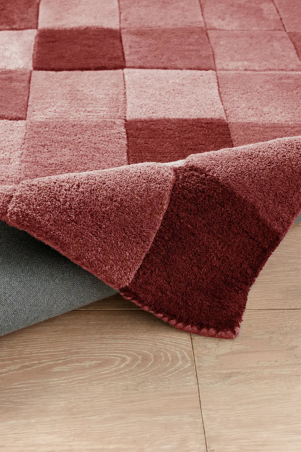 Burgundy checkered wool rug with plush texture and deep tones