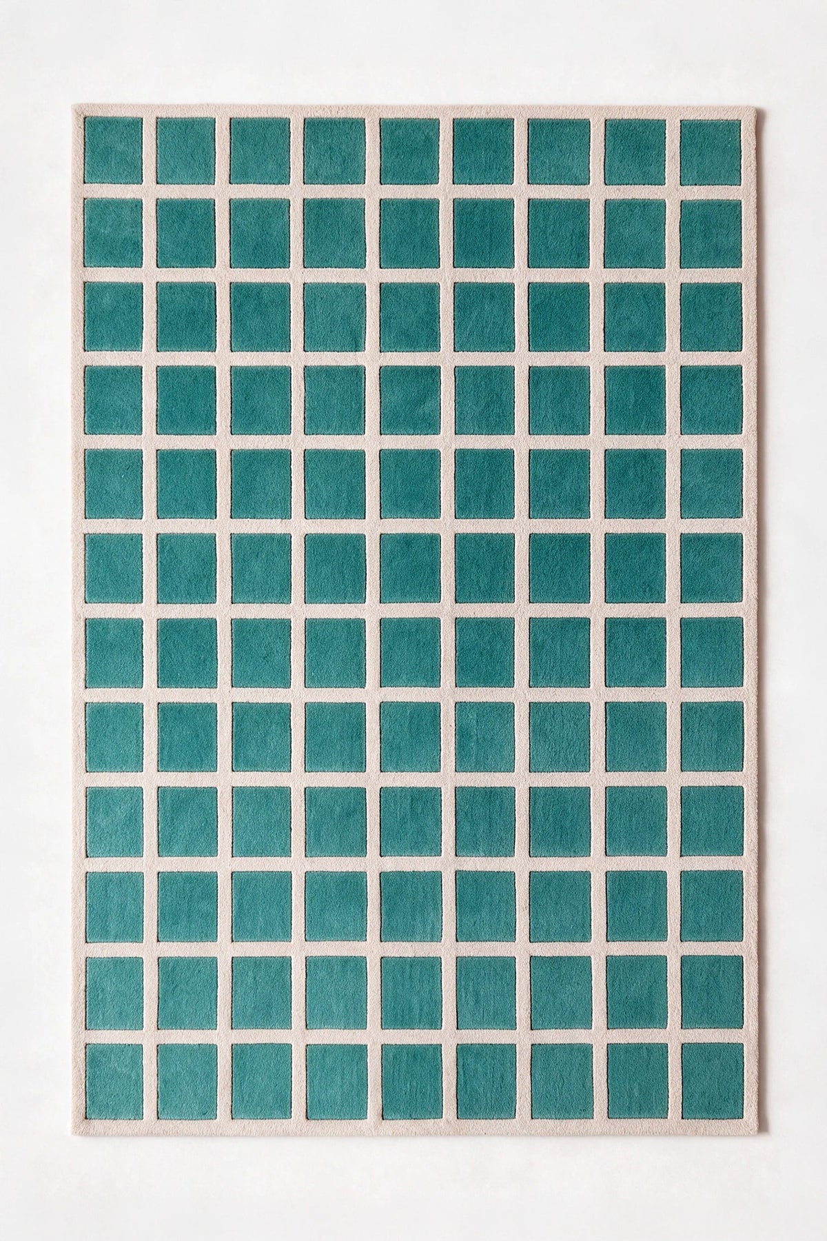 a tile hand-tufted wool rug in oat and teal, shown flat from above