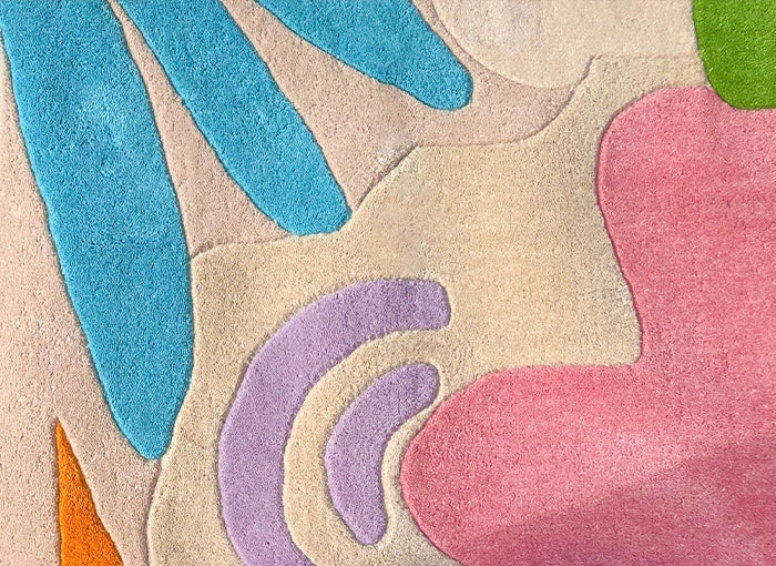 Colorful abstract rug with blue, pink, purple, and green shapes on a beige background