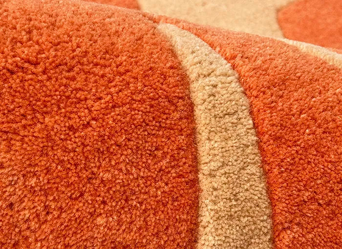 Close-up of a textured orange and beige carpet