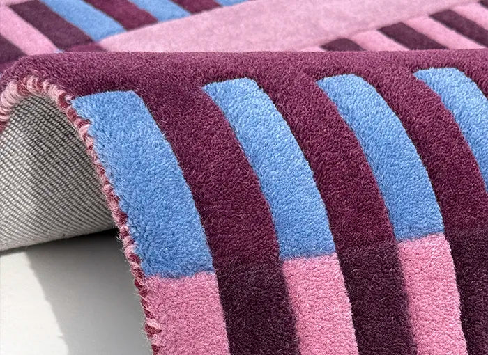 Close-up of a striped rug with purple, blue, and pink colors.