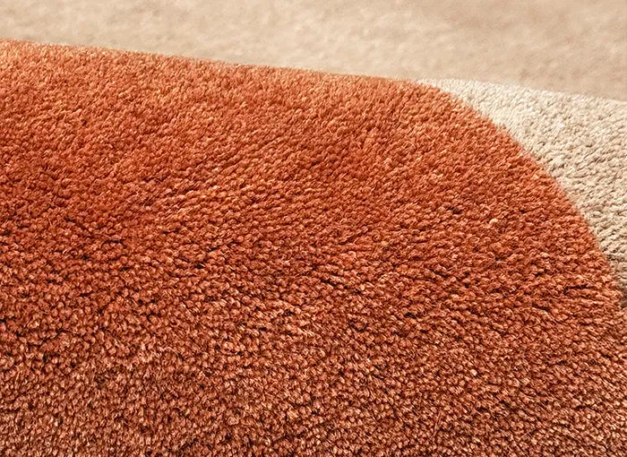 Close-up of an orange and tan wool rug
