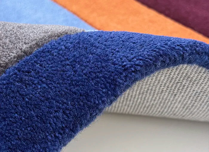 Close-up of blue textured carpet with multi colored stripes