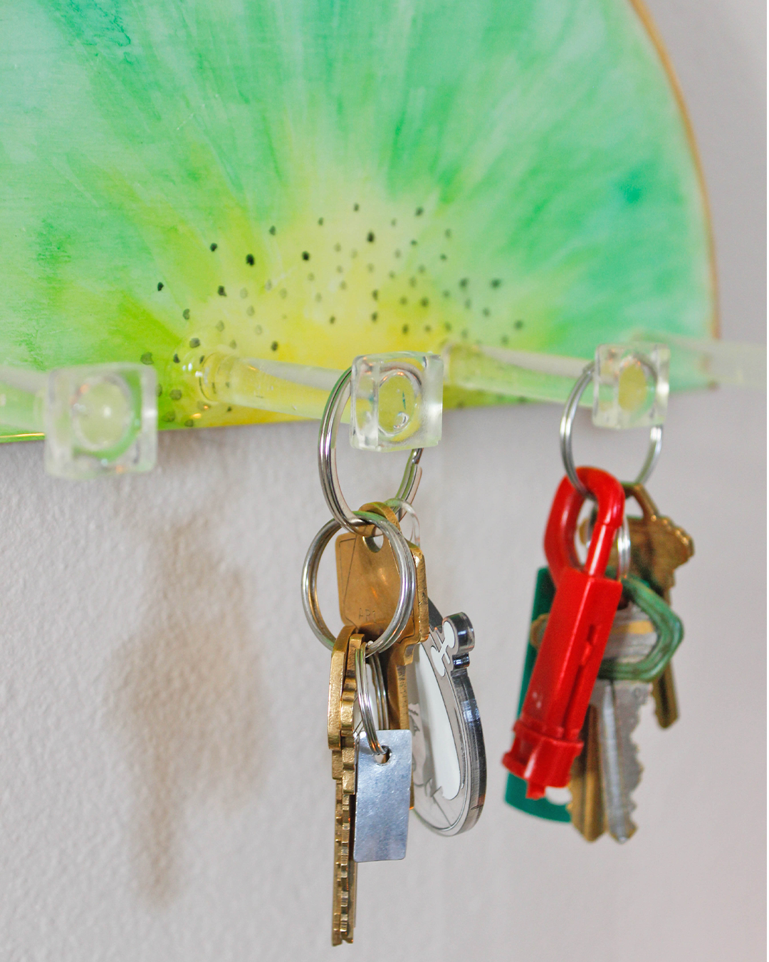 Artistic wooden key holder with a kiwi fruit theme, blending practicality with playful design for home organization.