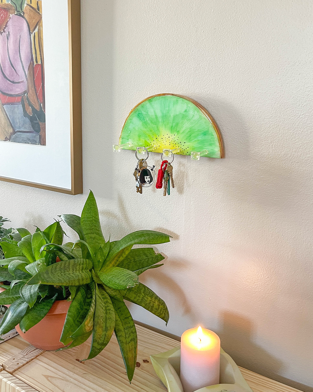 Colorful and functional kiwi slice key holder with four clear hooks for organizing keys and small items.