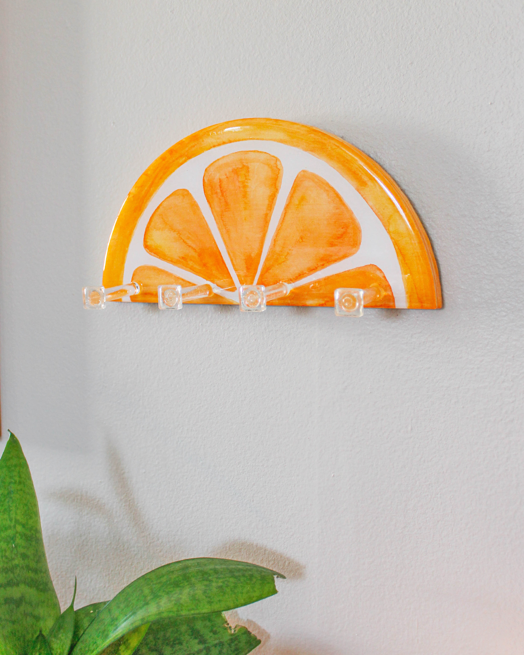 Unique hand-painted key holder inspired by an orange slice, adding a citrus touch to interior design