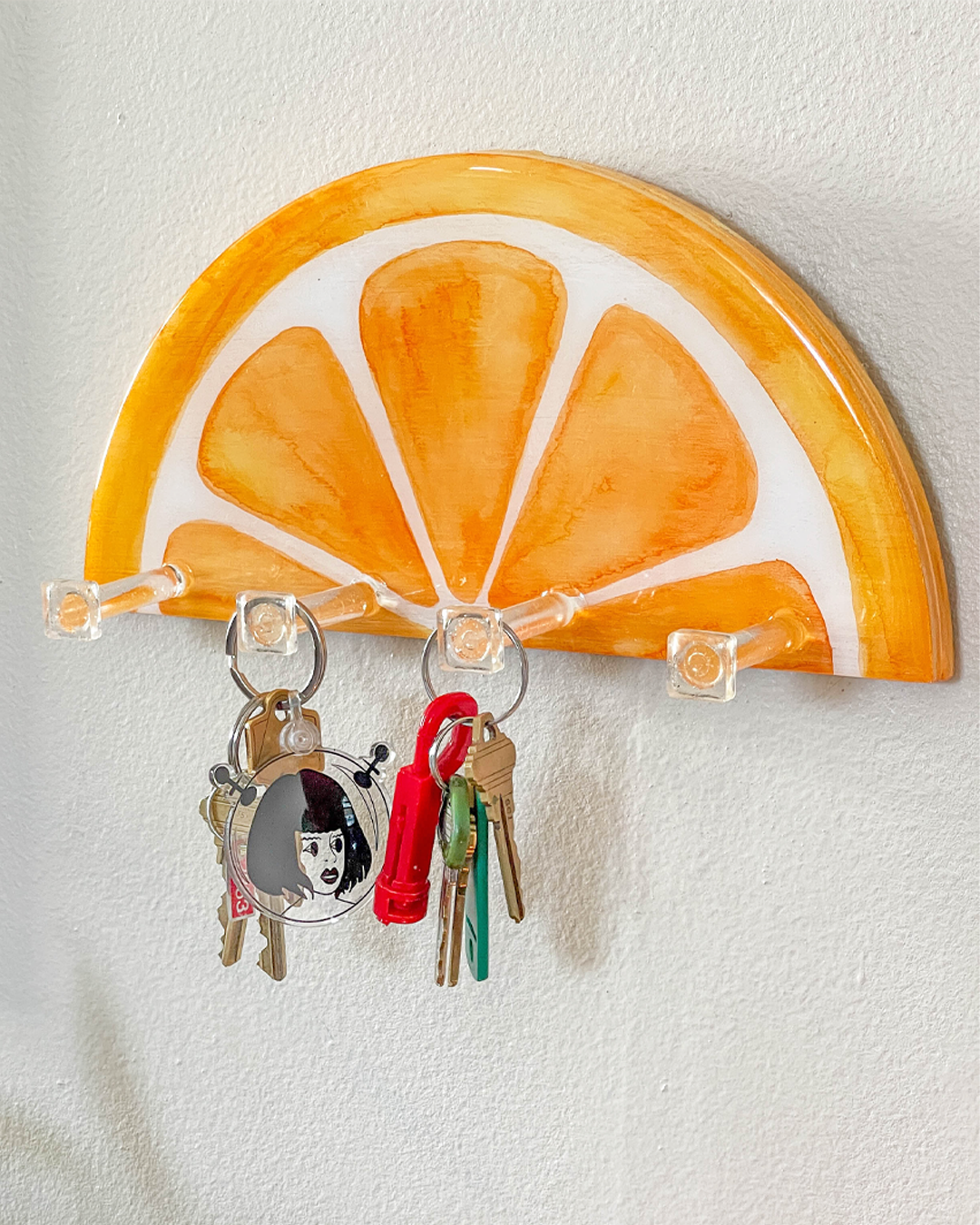 Artistic and functional key holder in the shape of an orange slice, handcrafted for home decor.