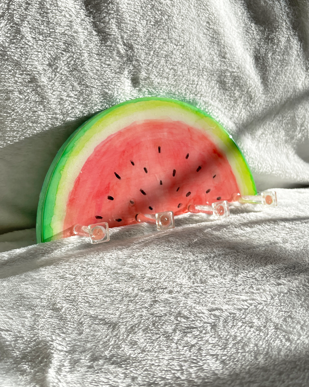 Colorful and functional watermelon slice key holder with four clear hooks for organizing keys and small items.