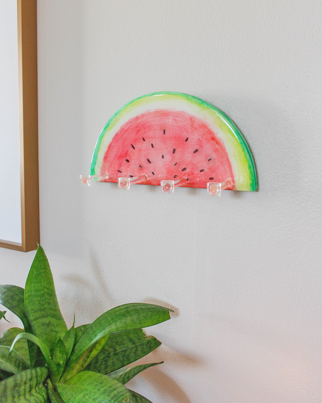 One-of-a-kind watermelon slice key holder, demonstrating its use for hanging jewelry, leashes, and small accessories.