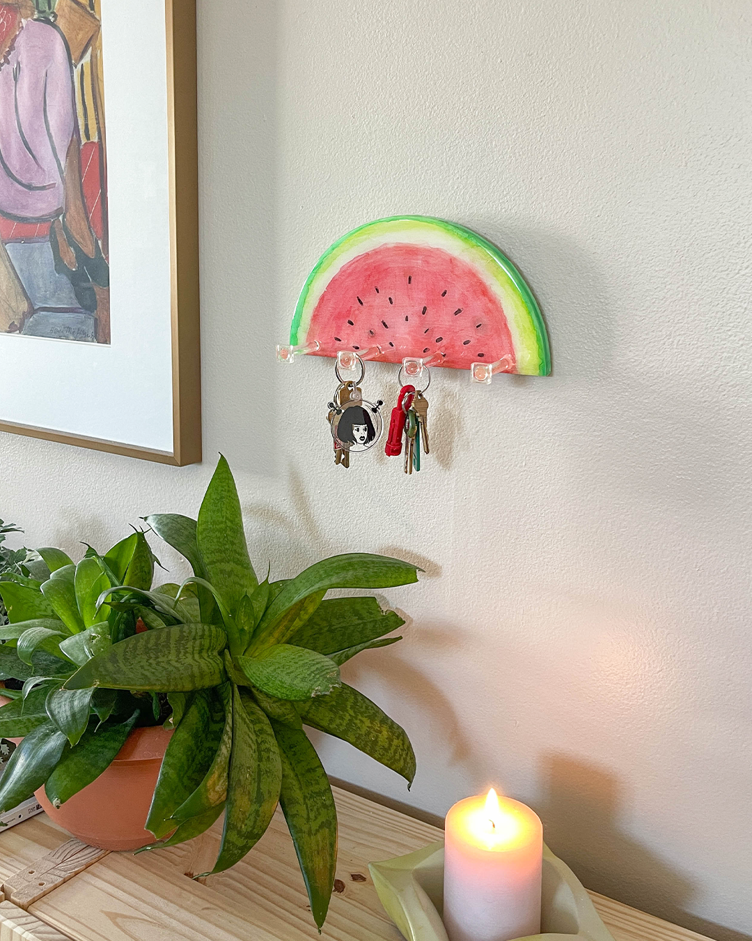 Unique hand-painted key holder inspired by a watermelon slice, adding a summery touch to any wall.