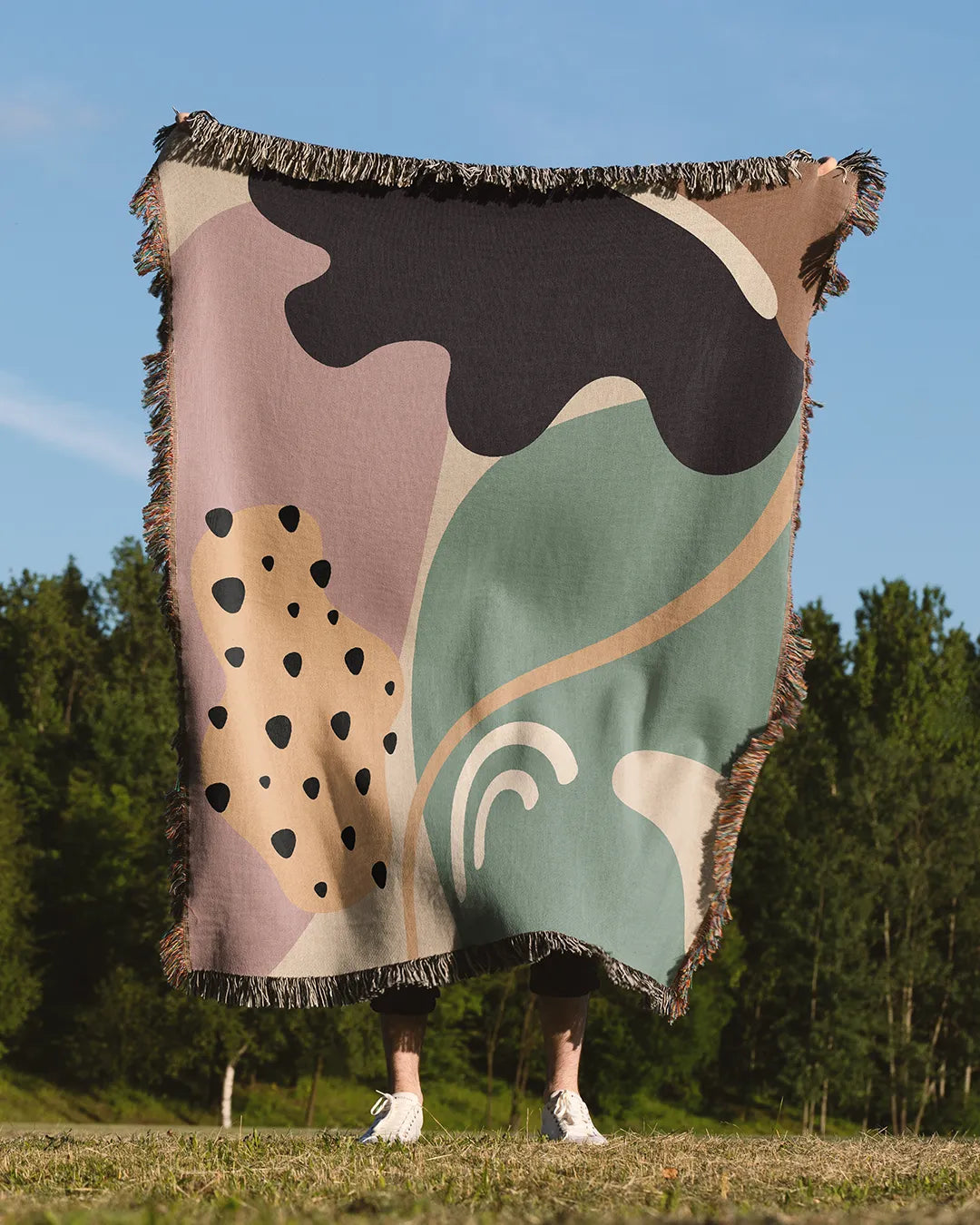 Retro-Futuristic Cotton Woven Throw Blanket in dusty pink, sage green, and cream with fringe edges.